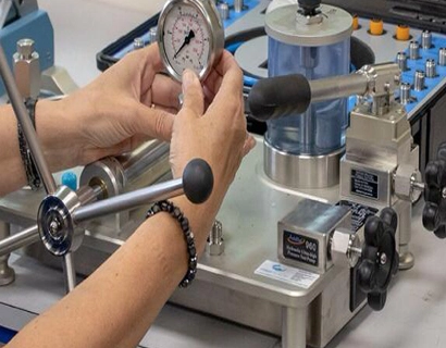 Technician performing pressure gauge calibration using specialized equipment