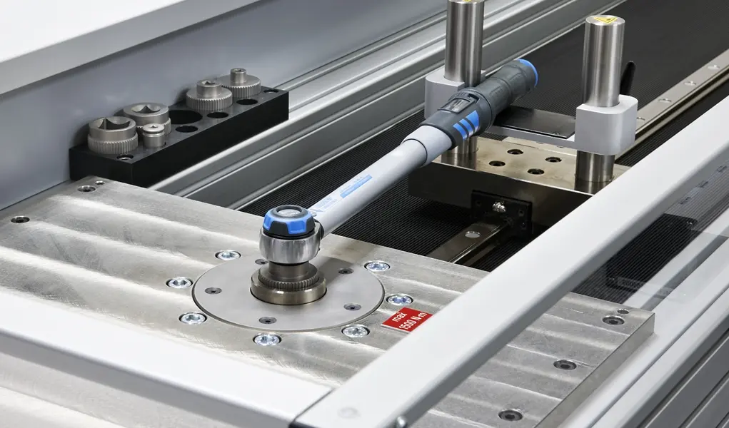 A torque wrench is being tested on a calibration machine